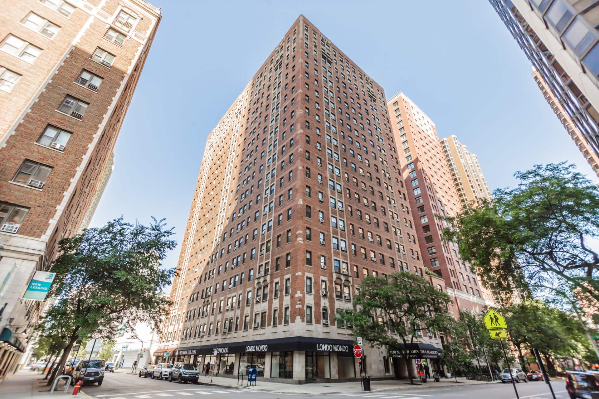 Tall brick building on city street corner.
