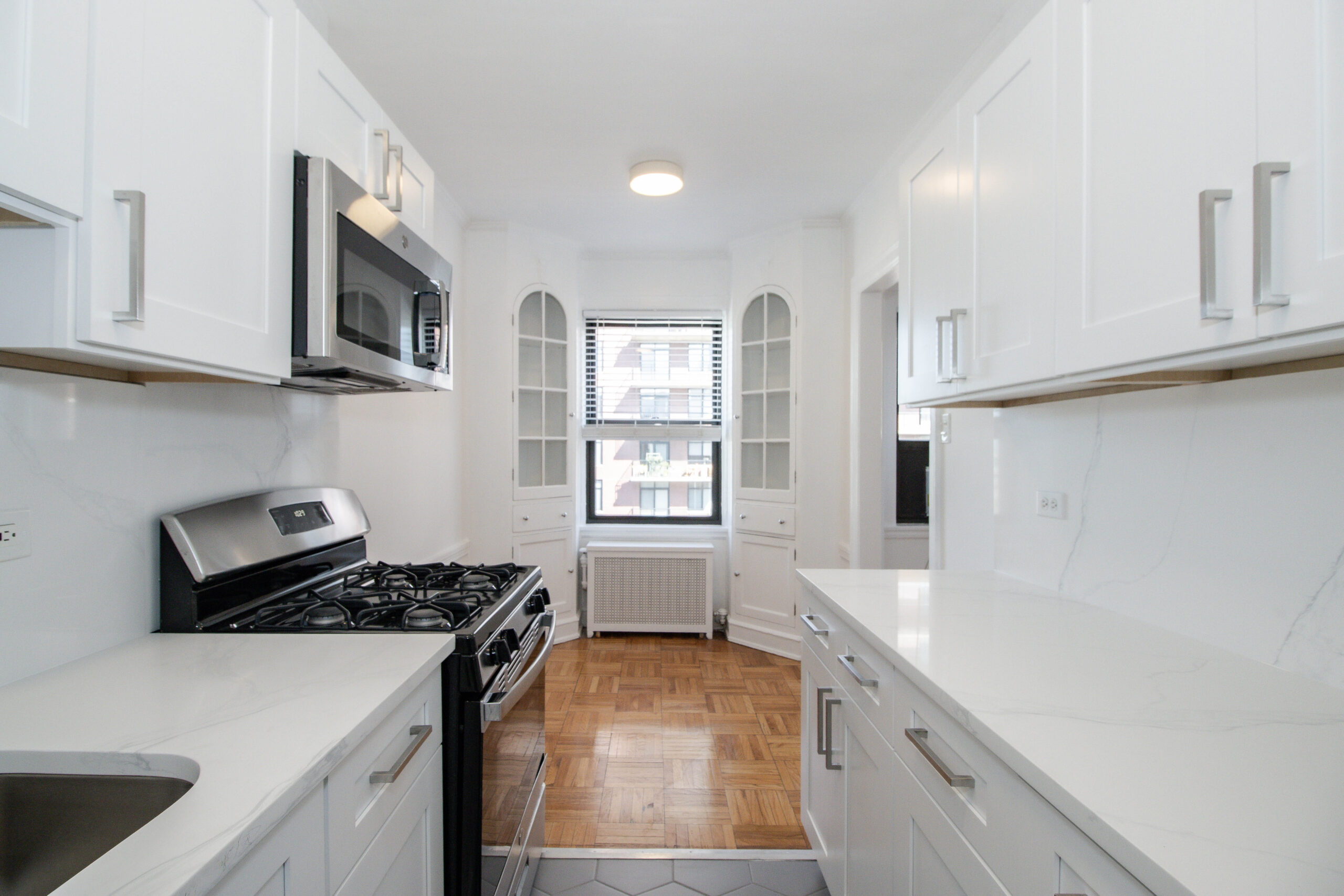Bright kitchen with white cabinets and gas stove.