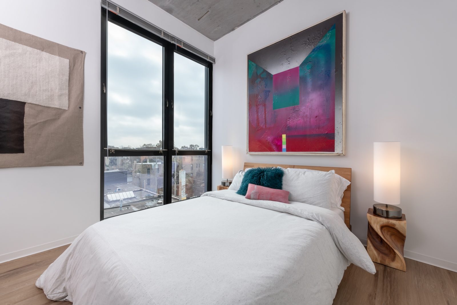 Modern bedroom with abstract art and large window
