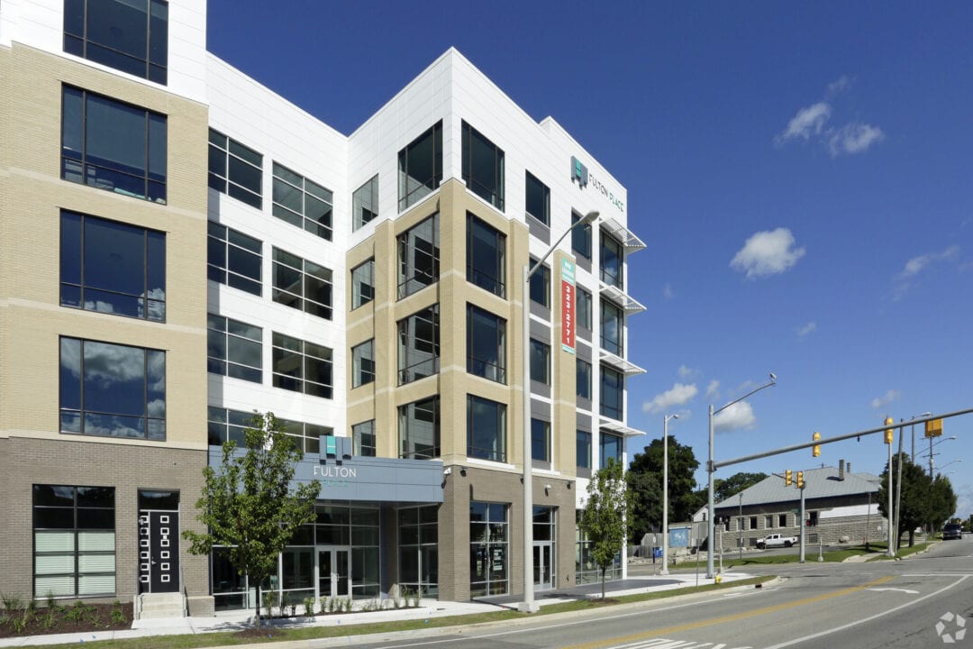 Modern office building exterior with clear blue sky.