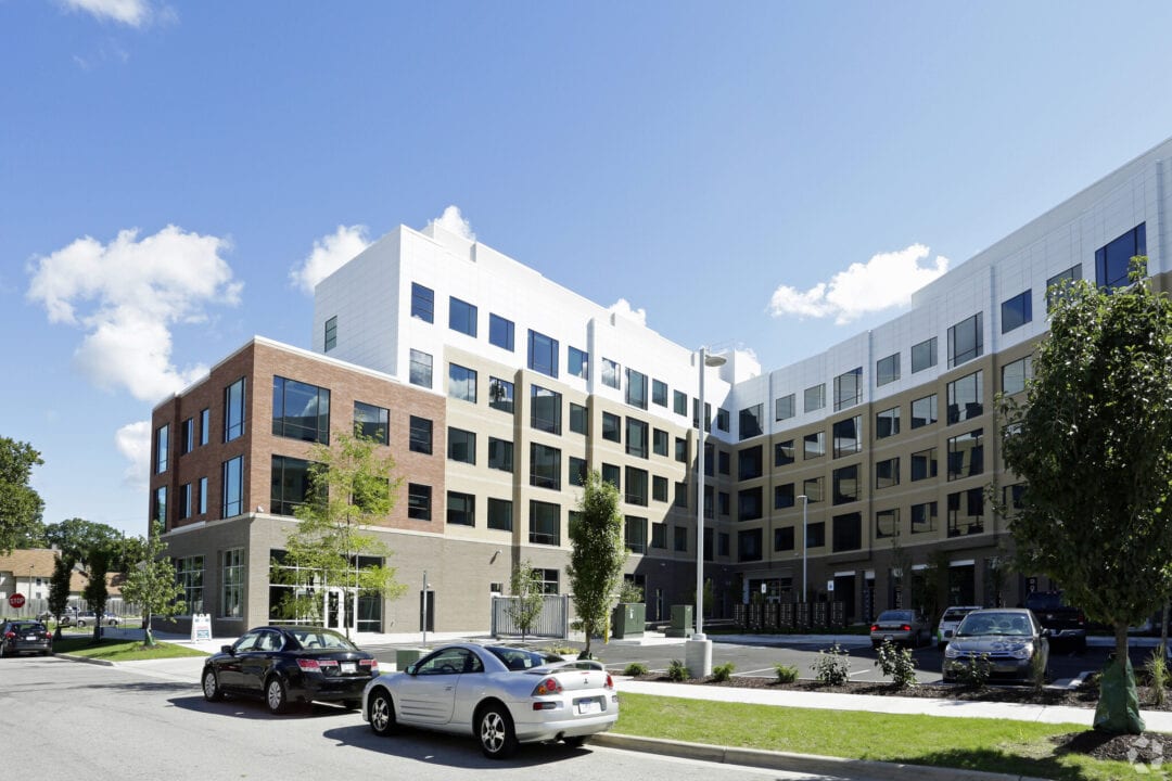 Modern apartment building with cars parked outside.
