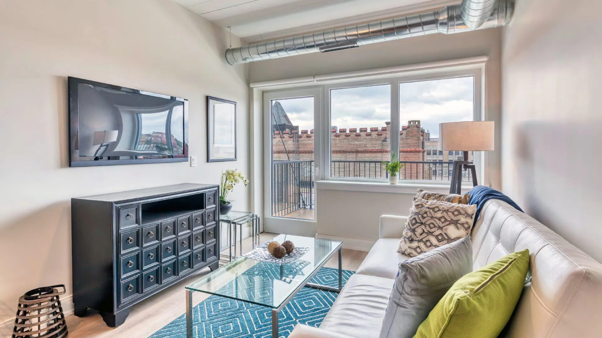 Modern living room with city view and TV.