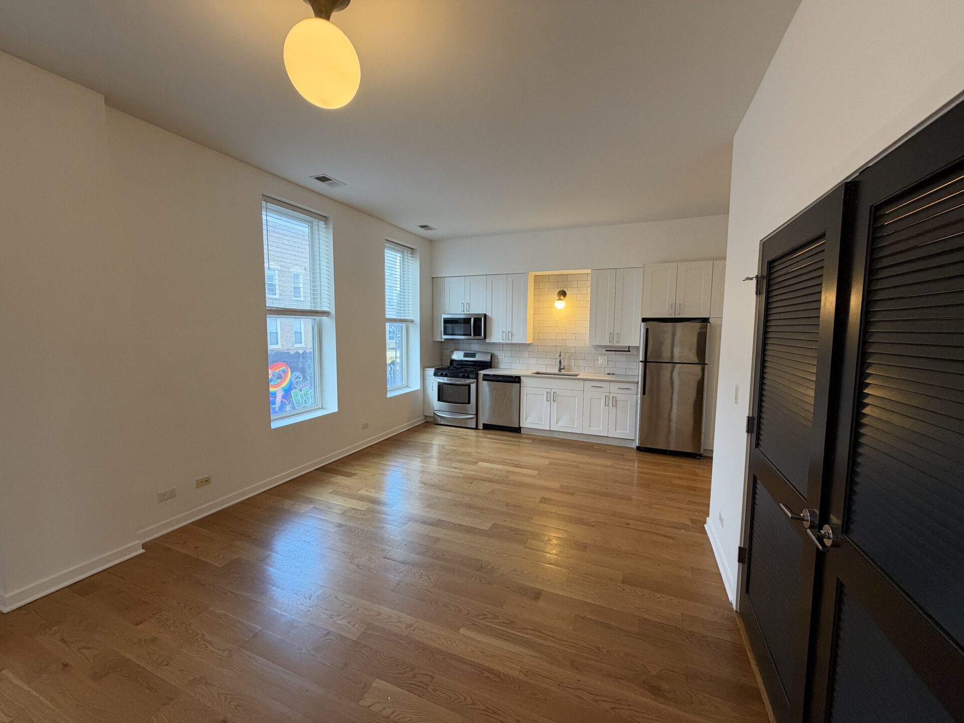 Open-concept apartment with hardwood floors and modern kitchen