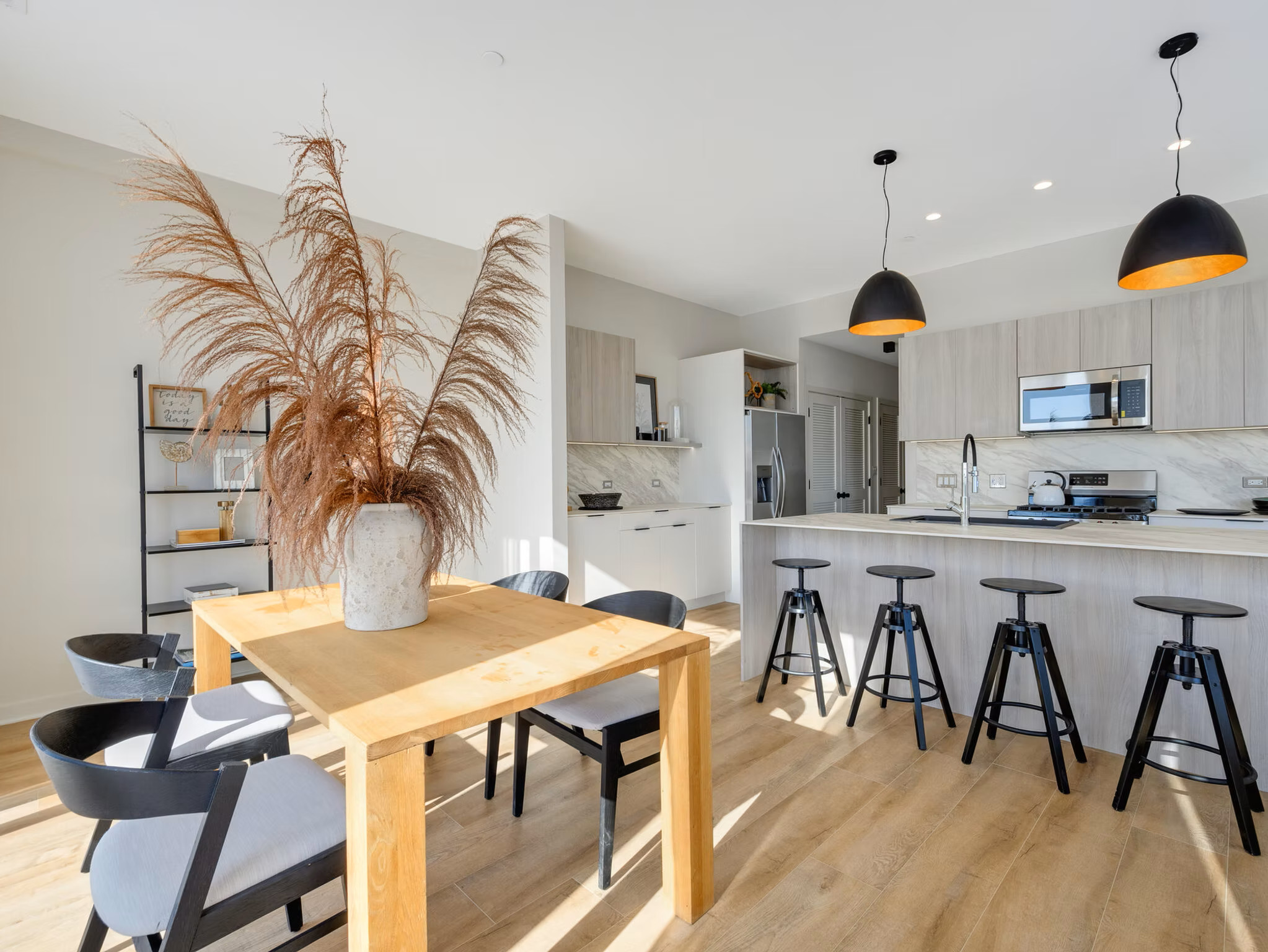 Modern kitchen and dining area with bar stools.