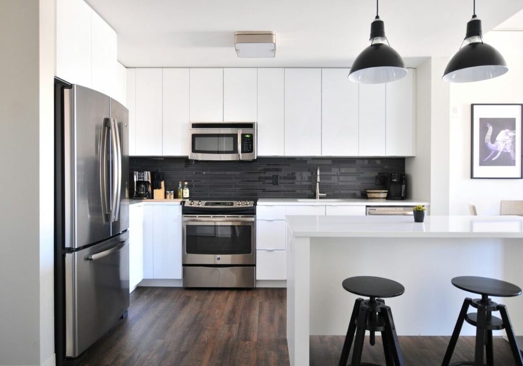Modern kitchen with white cabinets and stainless appliances.