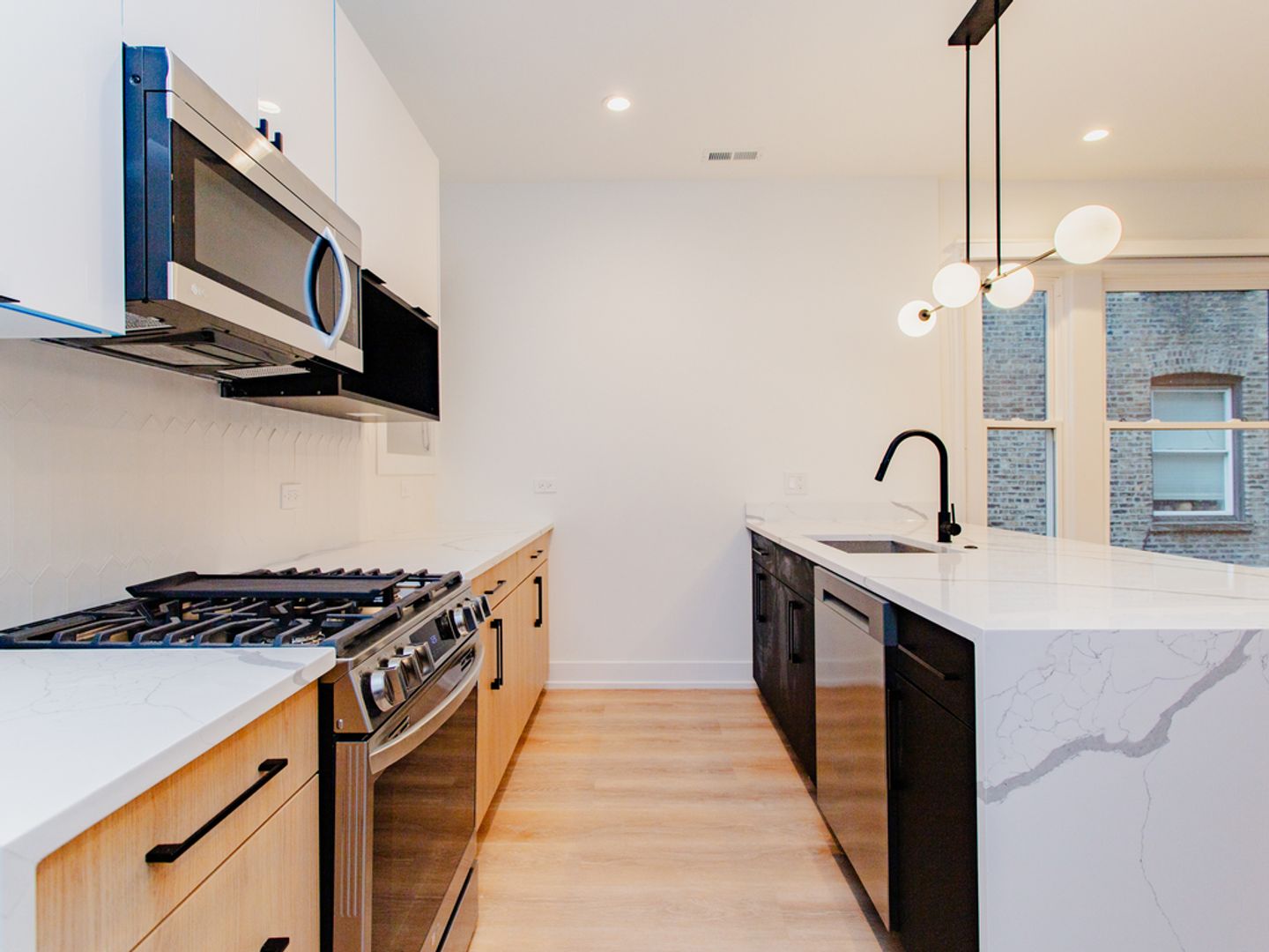 Modern kitchen with light wood cabinets and marble island