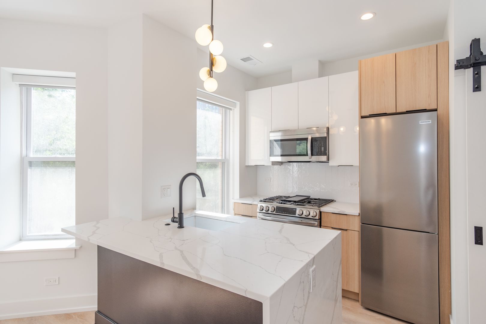 Modern kitchen with wood cabinets and marble island