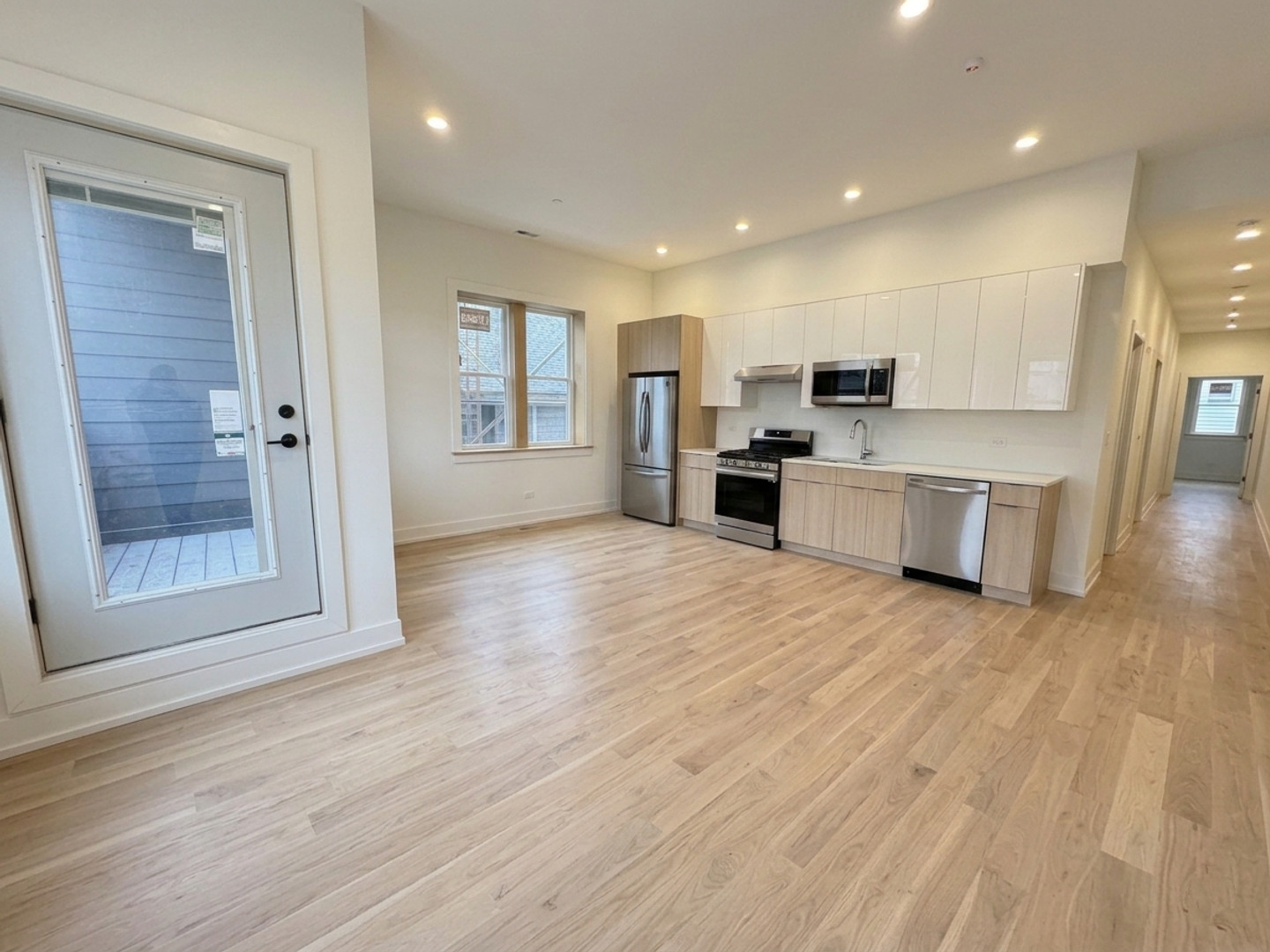 Modern open-concept kitchen with stainless steel appliances and hardwood floors