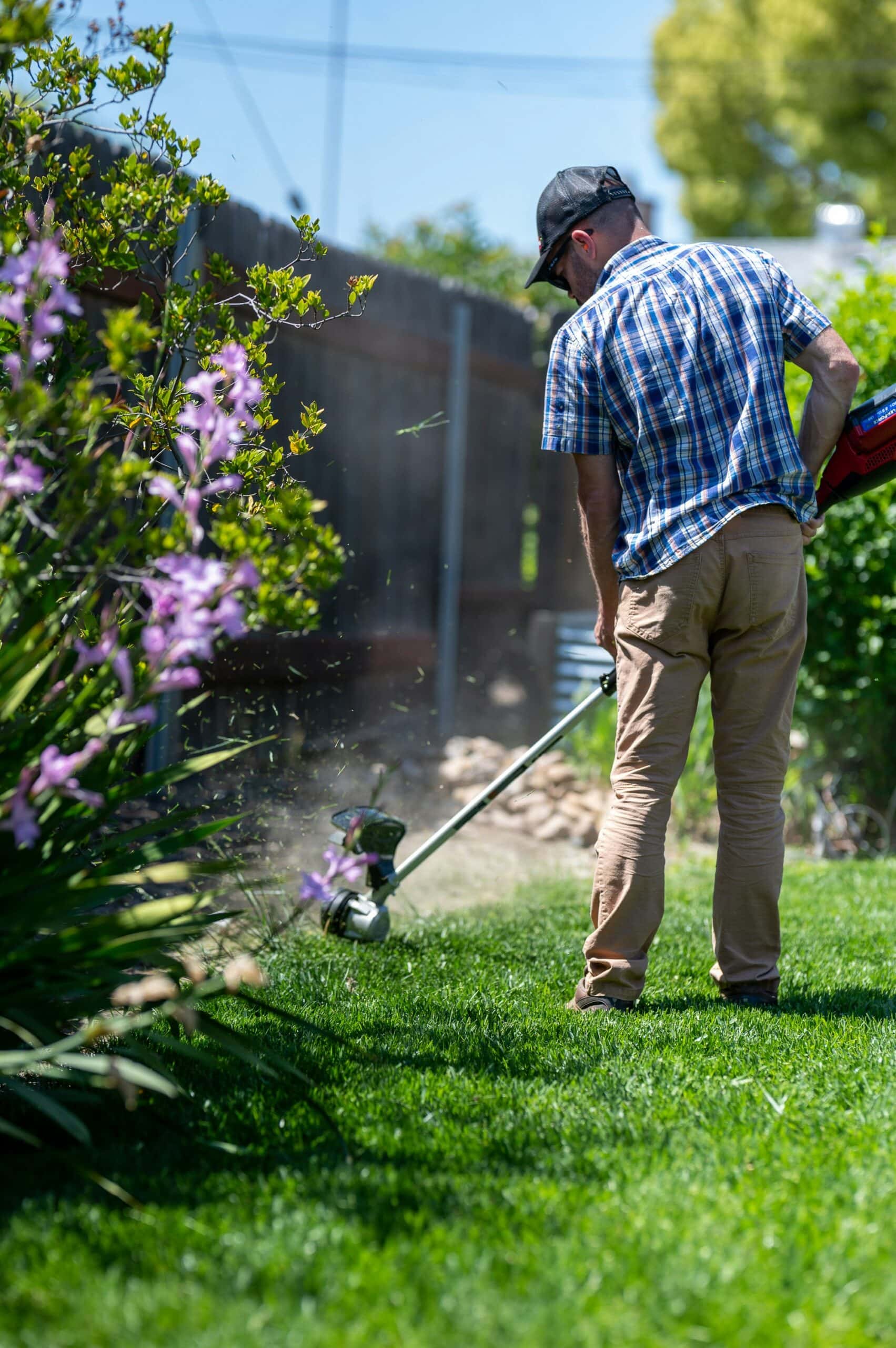 Man trimming grass with a weed eater.